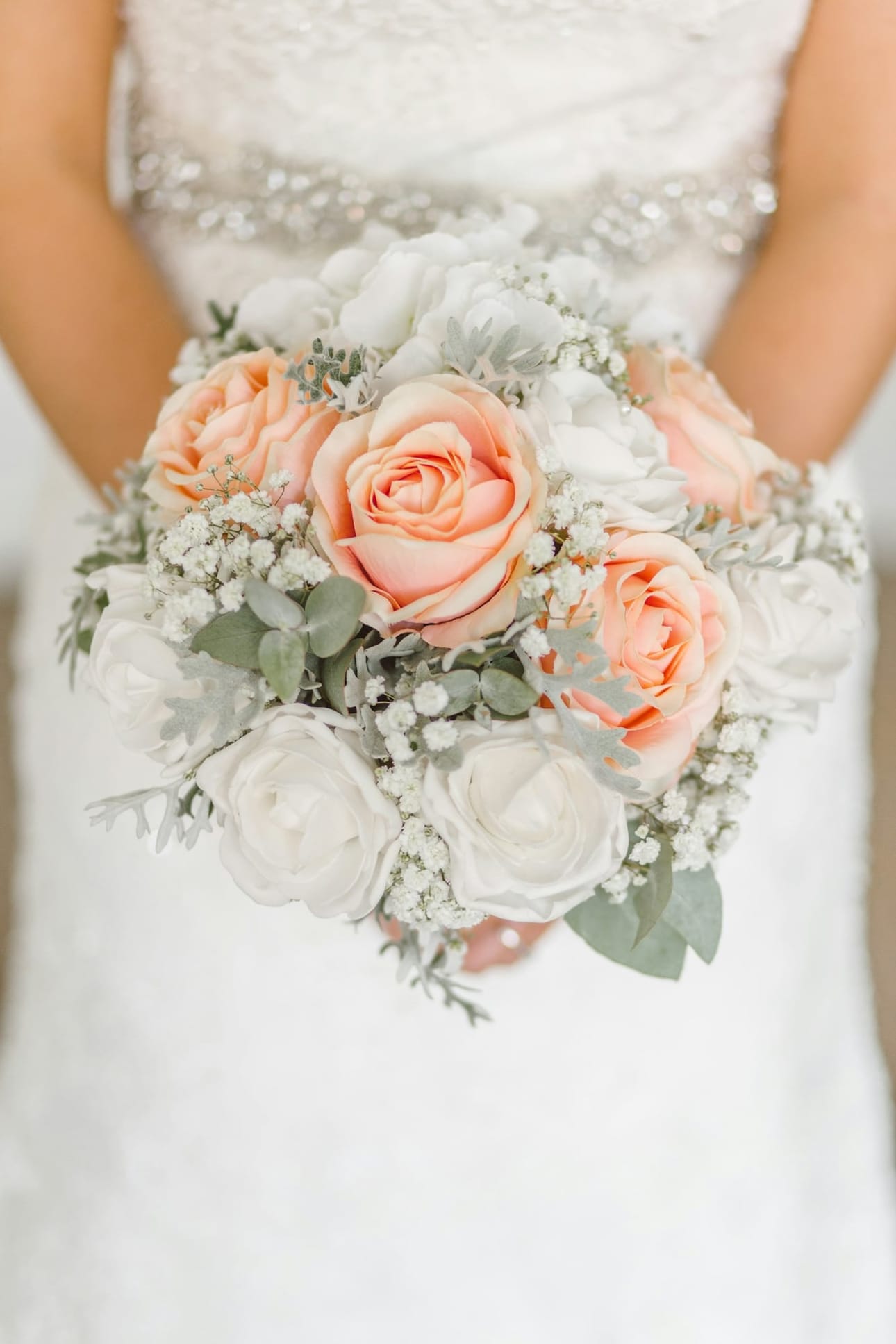 The bride holding a bouquet of peach roses